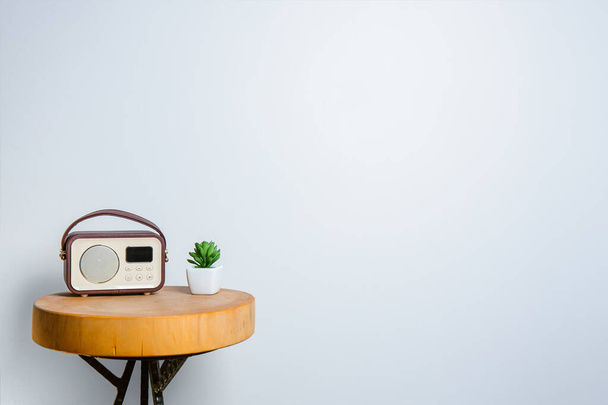 Retro rádió és egy frissítő zamatos növény, elegánsan elrendezve egy csiszolt fa asztal ellen fény fal, másolás Spacy, üres hely, banner, minimális belső kialakítás, elegáns bútorok - Fotó, kép