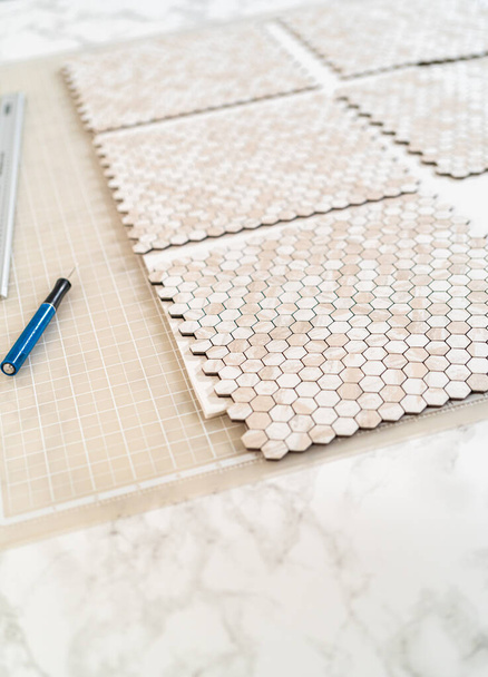 In het proces van het monteren van schil en plak mozaïek tegels op een schuimplaat, perfect voor het verbeteren van een voedsel fotografie studio esthetische. - Foto, afbeelding
