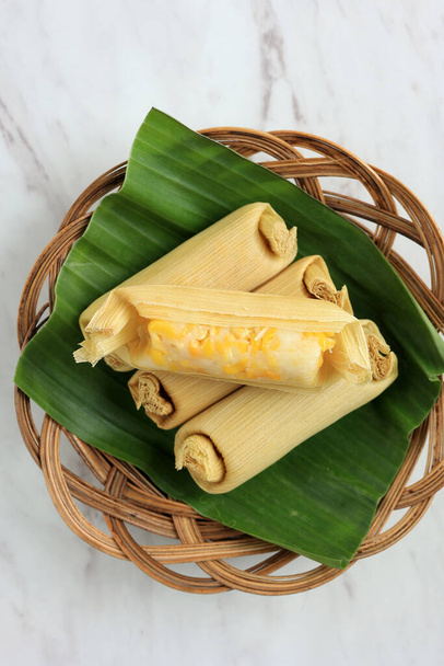 Lepet Jagung, pastel tradicional indonesio hecho de maíz y coco rallado, envuelto con cáscaras de maíz y luego al vapor - Foto, Imagen