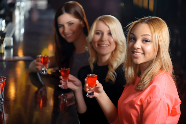 Three women have a drink in the bar - Фото, изображение