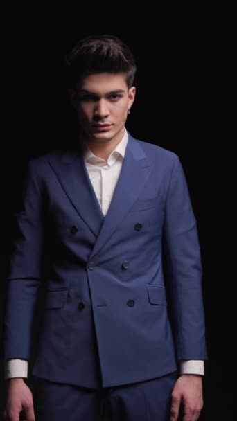 closeup of young handsome man in blue suit looking shocked while opening his mouth on black background - Footage, Video