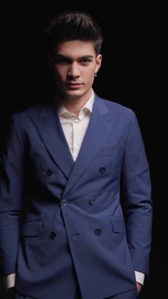project video of handsome elegant man in blue suit holding hands in pockets, being scared, acting surprised and laughing in front of dark background - Footage, Video