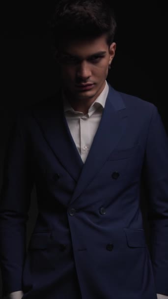 stilvoller Geschäftsmann im doppelreihigen blauen Anzug, der auf schwarzem Hintergrund mit Stroboskopeffekt steht und sexy aussieht - Filmmaterial, Video