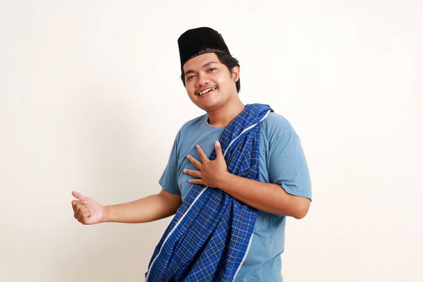 asiatico musulmano ragazzo punta lateralmente con felice faccia espressione - Foto, immagini