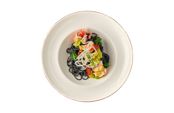 Pasta de mariscos italiana negra con camarones, tomates cherry y verduras. Pasta con tinta de sepia, macarrones de mariscos cocidos. - Foto, Imagen