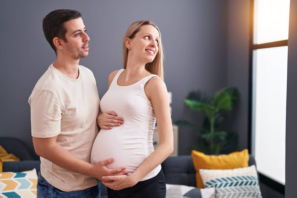 Muž a žena pár dotýkat břicho stojící doma - Fotografie, Obrázek
