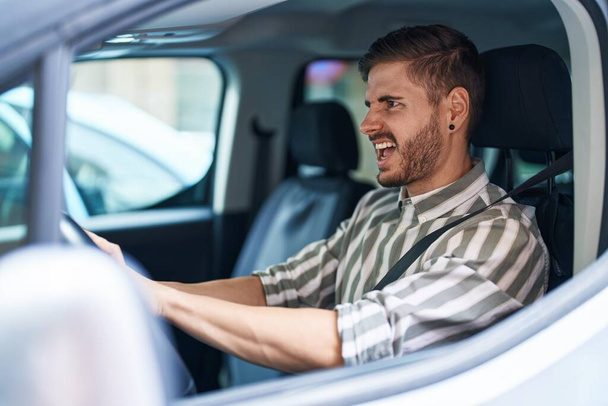 Young caucasian man stressed driving car at street - Foto, Imagem
