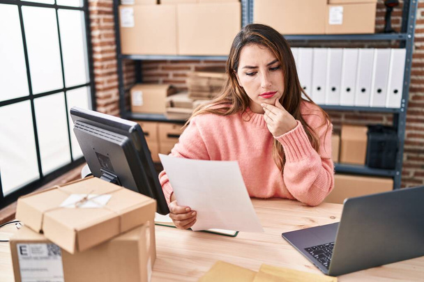 Молода красива іспанська жінка електронної комерції бізнес-працівник, використовуючи ноутбук читання документів в офісі
 - Фото, зображення