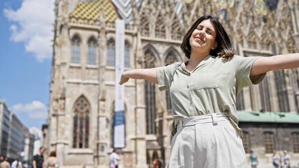 Jonge mooie Spaanse vrouw met open armen in St. Stephen 's Cathedral - Foto, afbeelding