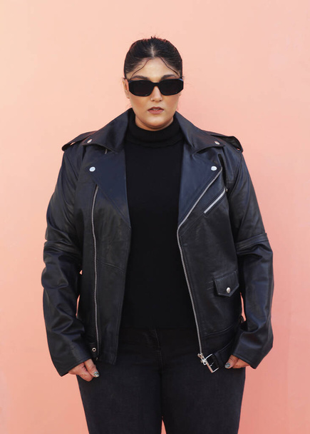 uma mulher com uma jaqueta preta e óculos de sol - Foto, Imagem
