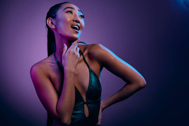 女性 スリム ブルー グラマー アジア 明るい ネオン ディスコ 輝く 紫 かなり 高級 女性 ダーク トレンディ カラフルな 肌 ファッション 光る 黒 作る - 写真・画像