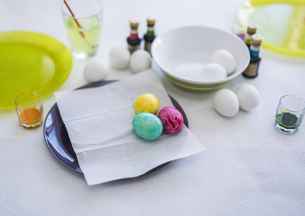 Крупный план детских окрашенных пасхальных яиц лежащих на тарелке на столе. Швеция. - Фото, изображение