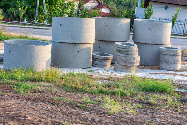 Betonnen drainagebuizen op de grond in een bouwplaats  - Foto, afbeelding