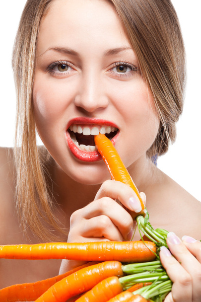 привлекательная женщина держит кучу моркови - Фото, изображение