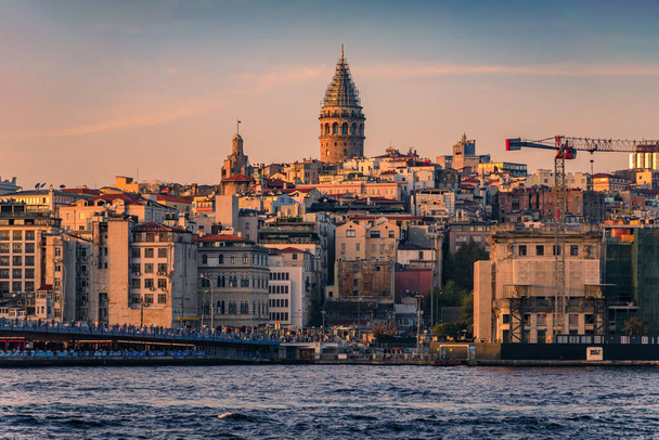 Zonsopgang stadsgezicht van de Karakoy gebied over Bosporus Straat door Galata Bridge met de Galata Tower op het gouden uur van zonsondergang in Istanbul, Turkije - Foto, afbeelding