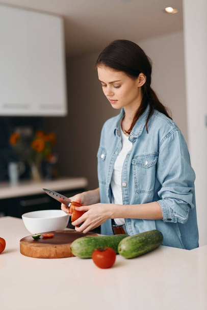 Приготовление здорового образа жизни: молодая женщина на красивой кухне, подготовка свежих овощей для веганского салата. - Фото, изображение