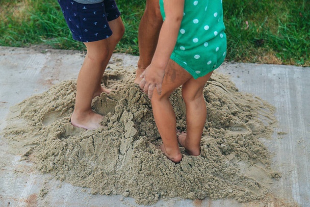 Kinder spielen mit Sand auf der Straße. Selektiver Fokus. Kinder. - Foto, Bild