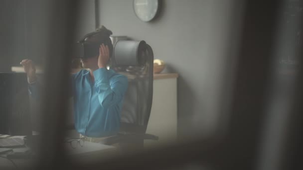 Nainen VR kehittäjä virtuaalitodellisuus kuulokkeet istuu pöydän ääressä toimistossa ja vuorovaikutuksessa näkymätön käyttöliittymä - Materiaali, video