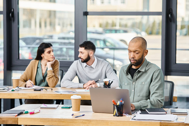 Drei Personen treffen sich in einem produktiven Meeting, kauern um einen Laptop und diskutieren ein Projekt in einem modernen Büroumfeld.. - Foto, Bild