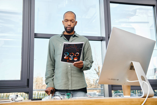 Um homem em um escritório em pé diante de um grande monitor de computador, imerso em trabalho em um projeto para o seu negócio. - Foto, Imagem