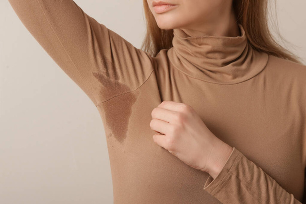  Close up imagem de mulher em gola alta de algodão bege com remendo de suor sob axila - Foto, Imagem