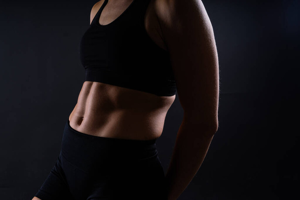 Primer plano de la espalda de la mujer con músculos después del entrenamiento. Culturista femenina con bíceps perfectos - Foto, Imagen