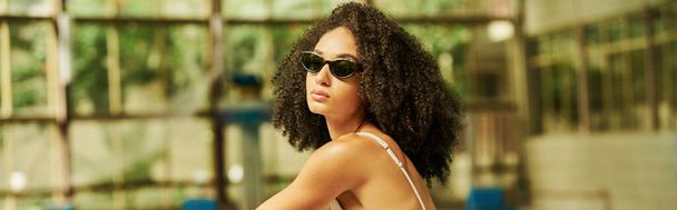 young african american woman in a swimwear and trendy sunglasses posing during vacation, banner - Photo, image