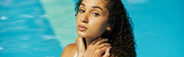 young black woman with wet curly hair standing cool blue pool water and looking at camera, banner - Foto, immagini