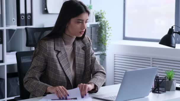 Elégedetlen kaukázusi nő alkalmazott számviteli üzlet hivatalban dokumentumok és laptop. A beruházások és a vállalat költségvetésének ellenőrzése, a papírmunka felülvizsgálata. - Felvétel, videó