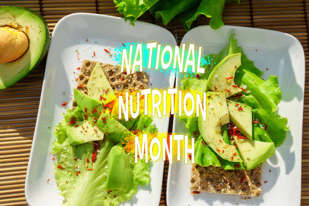 Świętowanie National Nutrition Month ze świeżą sałatką i awokado na Crisp Ryebread - Zdjęcie, obraz