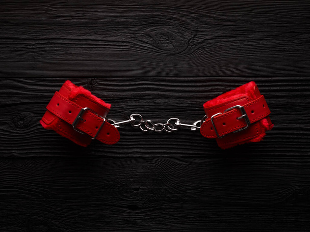 Fondo BDSM con esposas esponjosas de color rojo brillante y cuerda para atar - Foto, Imagen