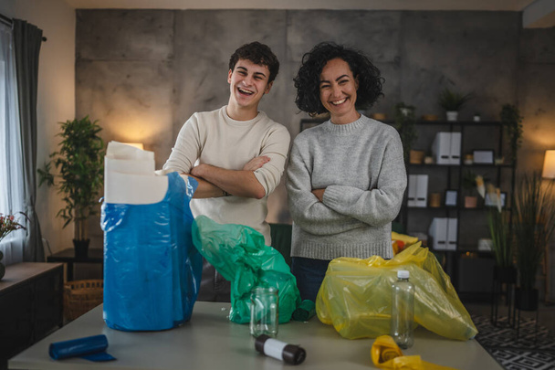 anya és fia nő és tizenéves férfi család újrahasznosítás otthon válogatás hulladék műanyag papír és üveg zsákok fenntartható életkoncepció - Fotó, kép