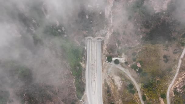 Vista dall'alto della strada Kanan che attraversa la nebbia al mattino, Malibu, periferia di Los Angeles, California, USA. Veduta aerea del tunnel nelle montagne di Santa Monica. formazioni nuvolose che coprono autostrada, filmati 4k - Filmati, video