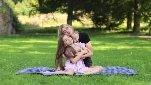 Matka a dcera se objímají na pikniku v parku. - Záběry, video