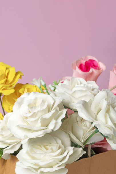 Un bouquet di rose multicolori in una scatola su sfondo rosa per San Valentino - Foto, immagini