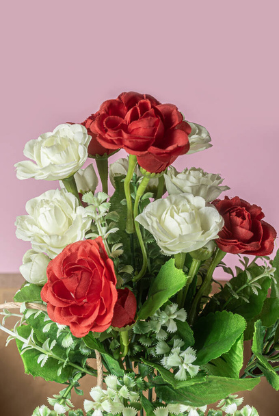 Ένα μπουκέτο με κόκκινα, λευκά και ροζ τριαντάφυλλα σε ροζ φόντο. - Φωτογραφία, εικόνα