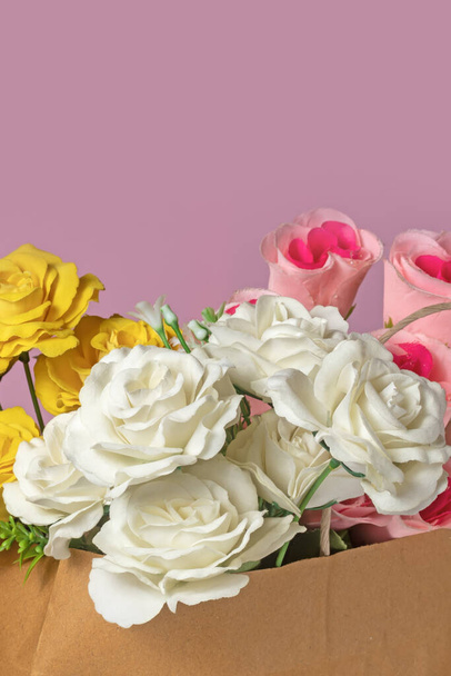 Μπουκέτο με λευκά τριαντάφυλλα και κίτρινα τριαντάφυλλα σε κουτί σε ροζ φόντο. - Φωτογραφία, εικόνα