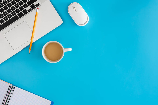 Conceito de escritório. Laptop com notebook e xícara de café em fundo azul. Vista superior com espaço de cópia, flat lay. - Foto, Imagem