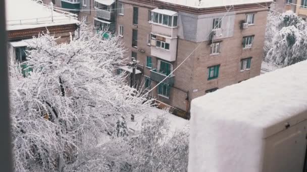 Výhled z okna, Zimní město Krajina ve dvoře starých obytných budov. Horní pohled. Panorama. Sníh leží na střechách vícepodlažních budov, stromy jsou pokryty sněhem. Zataženo. - Záběry, video