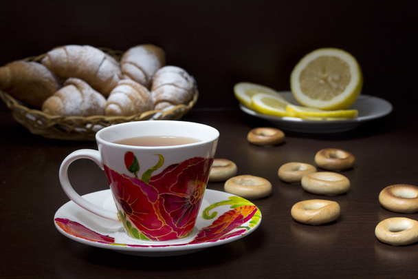 kopje thee met papavers, croissants  - Foto, afbeelding