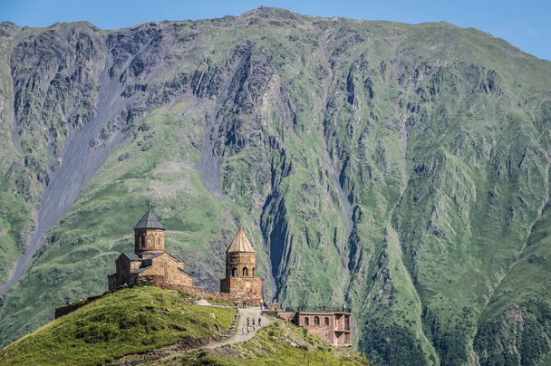 Tsminda Sameba - Iglesia de la Trinidad en las montañas del Cáucaso en la aldea de Gergeti cerca de Stepantsminda en Georgia - Foto, Imagen