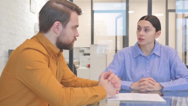 Zakenman in gesprek met vrouwelijke werknemer in Office - Video