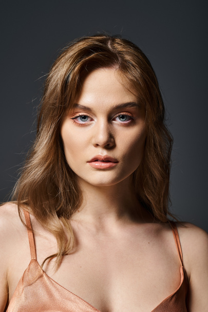 Beauty portrait of an attractive sensual young woman with blue eyes over dark gray background - Fotó, kép