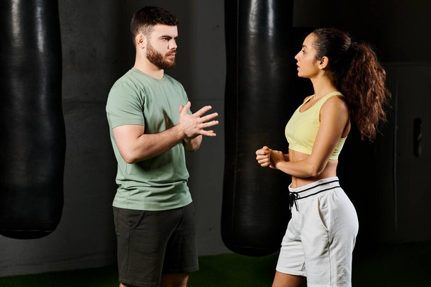 A male trainer demonstrates self-defense techniques to a woman in a gym setting. - Photo, Image
