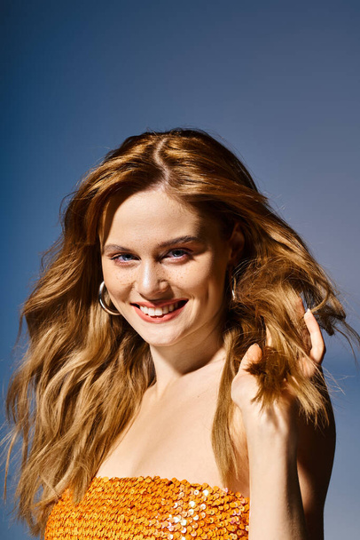 Beauty portret van glimlachende aantrekkelijke vrouw op zoek naar camera, op blauwe achtergrond - Foto, afbeelding