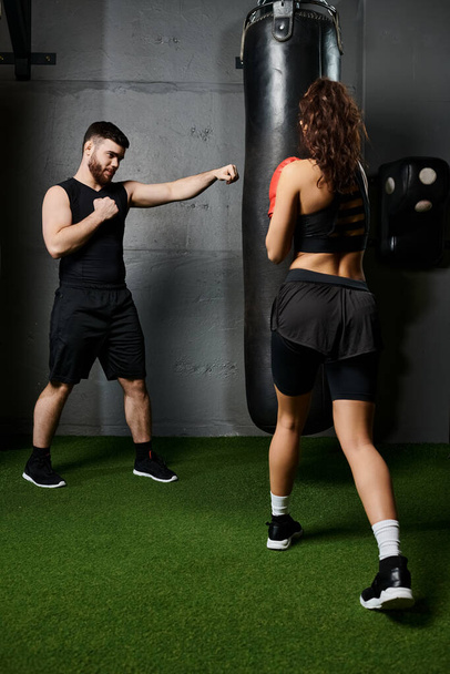 Тренер-мужчина поддерживает брюнетку-спортсменку, когда она боксирует в современной спортивной среде. - Фото, изображение