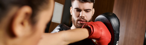 A woman with a beard wearing a red boxing glove, ready for action. - Photo, Image