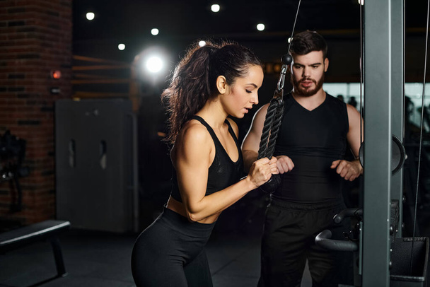 Ein Personal Trainer motiviert eine brünette Sportlerin während einer intensiven Trainingseinheit im Fitnessstudio. - Foto, Bild