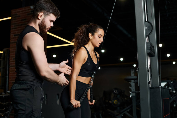 Osobisty trener stoi obok brunetki sportowca w siłowni, prowadząc i wspierając ją podczas sesji treningowych. - Zdjęcie, obraz