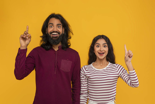 Ispirato giovane indiano uomo e donna mostrando gesto eureka alzando le dita e smorzando, coppia indù eccitato hanno grande idea creativa, soluzione, isolato su sfondo studio giallo - Foto, immagini